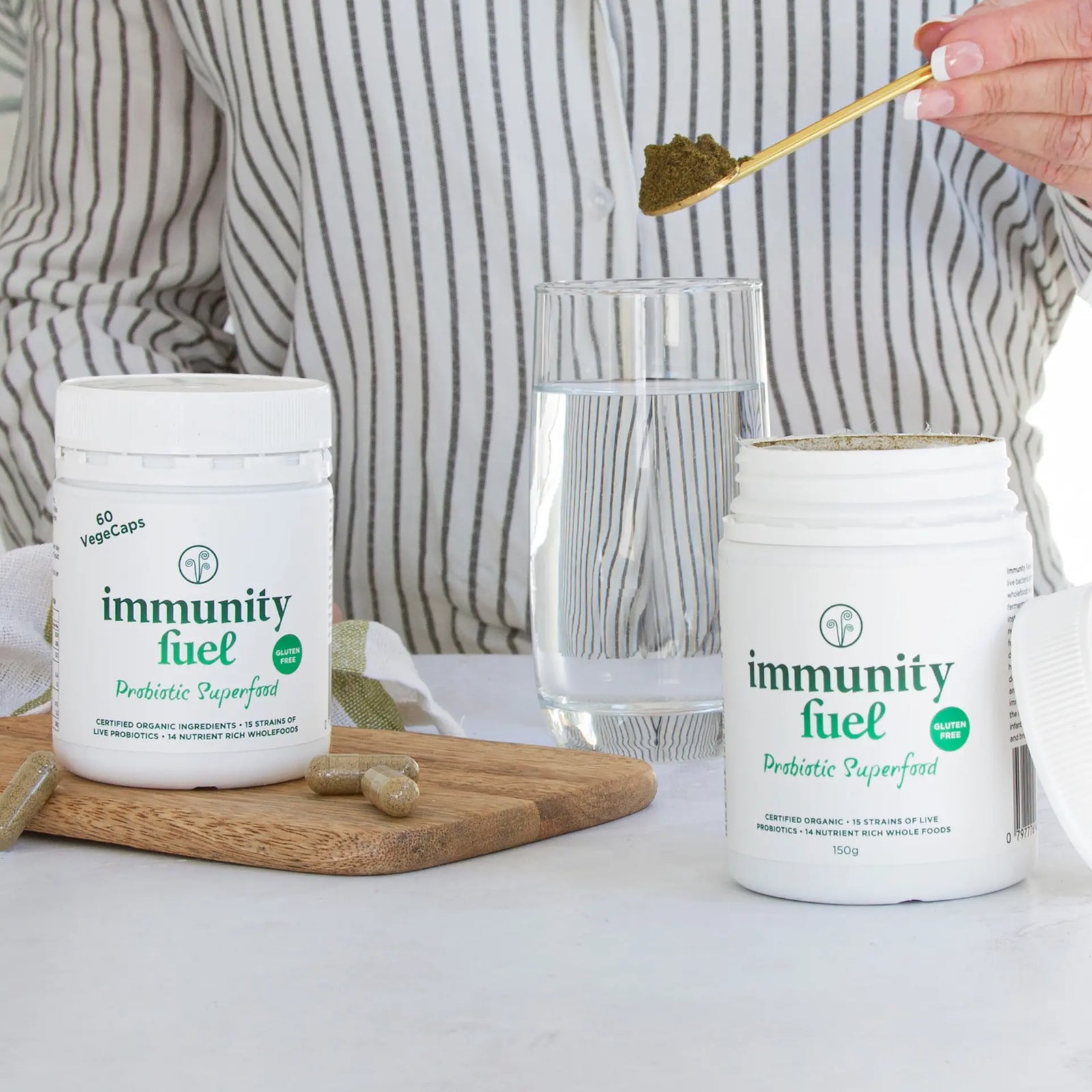 Two containers of gluten free 'immunity fuel' probiotic superfood with capsules and powder on a white background
