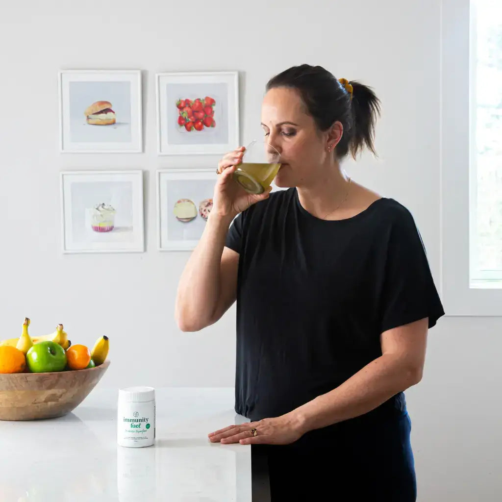 woman drinking immunity fuel probiotic superfood for her gut health and hormone support
